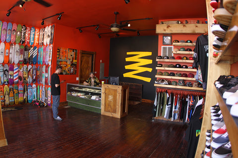 Interior of a Blacklist shop showing deck wall, register counter, and branded signage