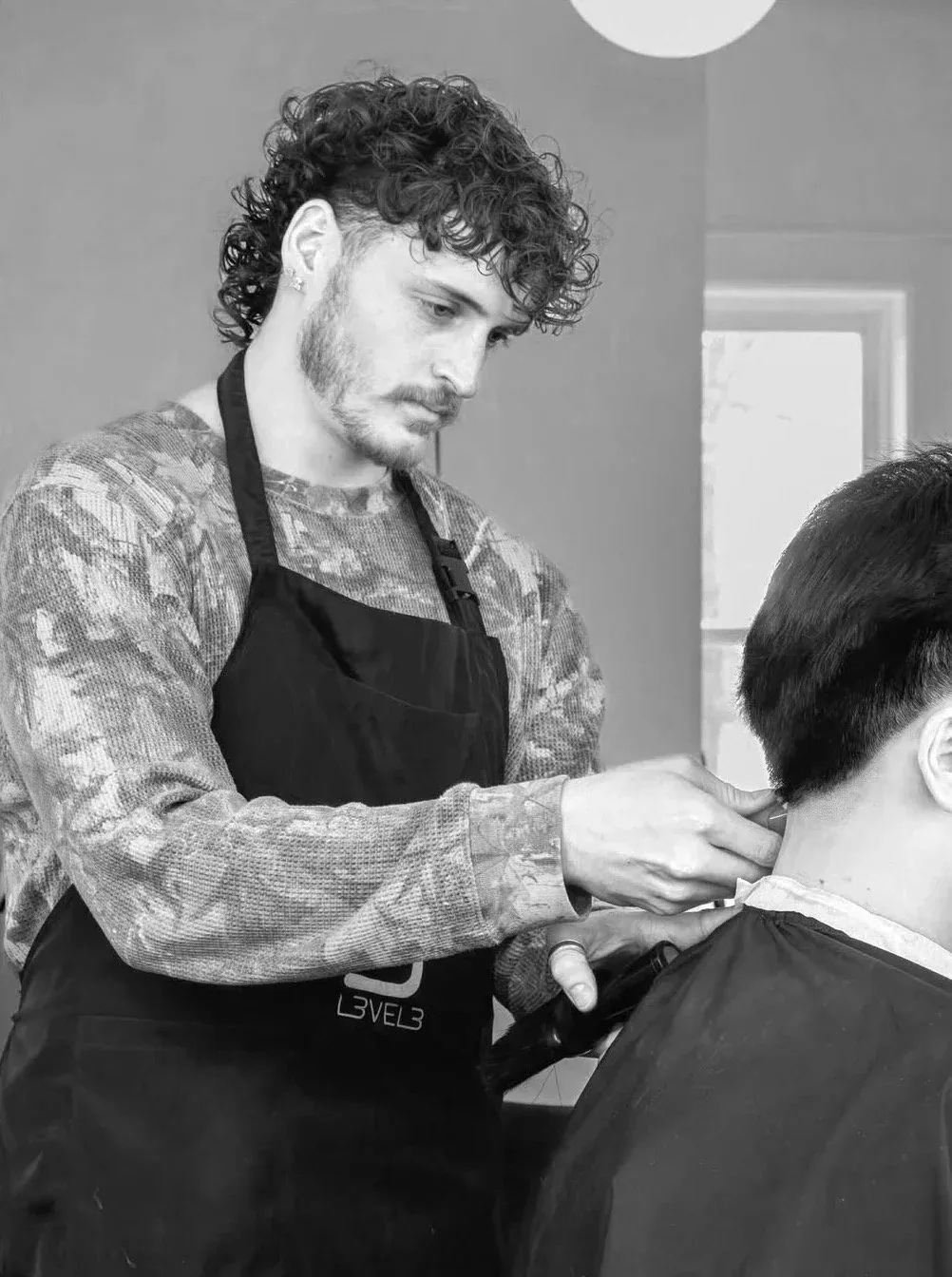 A Cutman barber fading a client's haircut in the chair