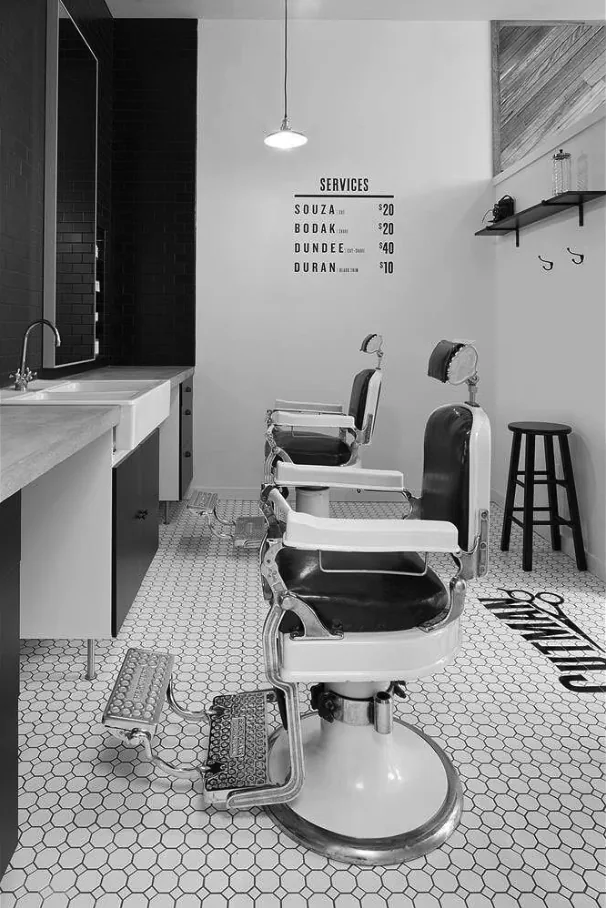 Barber chairs and a services price list inside a Cutman shop