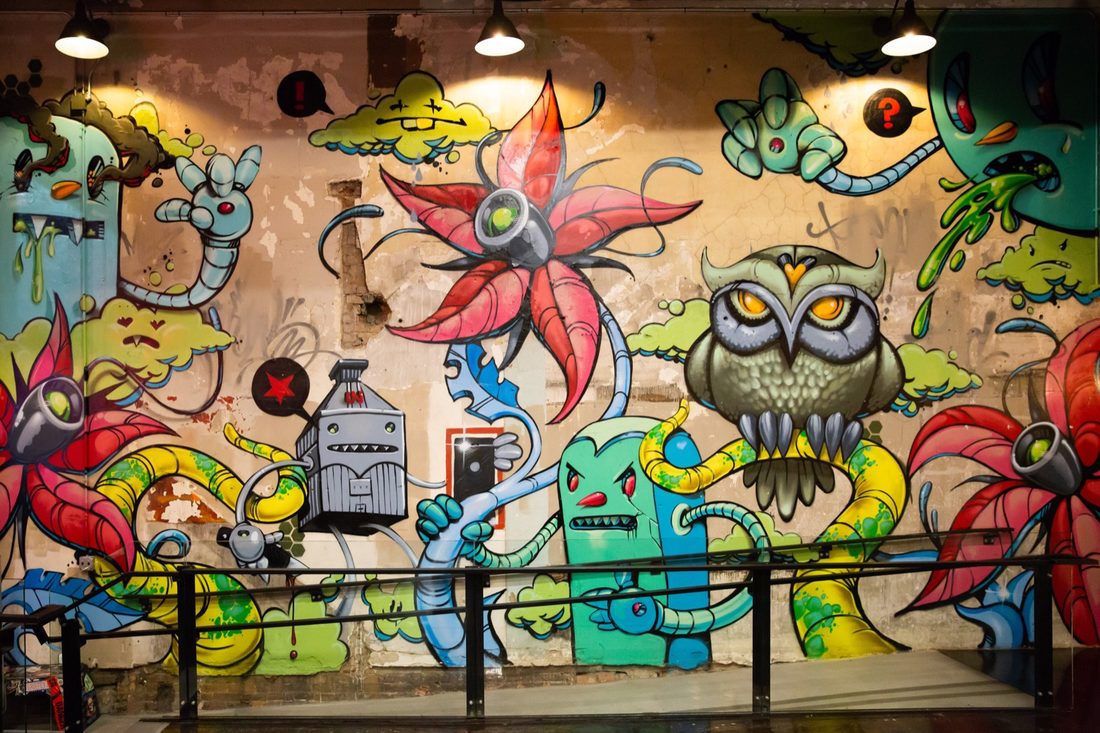 A large graffiti-style mural featuring an owl and cartoon characters painted on an interior wall of the store.